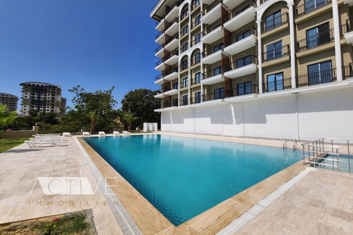 Apartment 42qm in Alanya, Erstbezug, unmöbliert, 1 Schlafzimmer, 1 Bad, Pool, seitlicher Meerblick